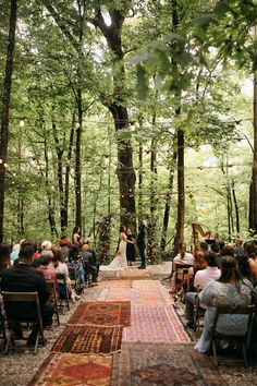 a wedding ceremony in the woods surrounded by trees