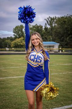 a cheerleader is holding her pom - poms in the air on a football field