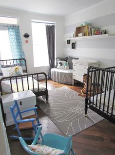 a baby's room with two cribs and a rug on the floor