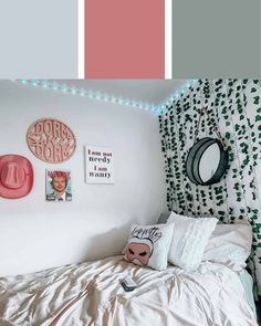 a bedroom with pink and grey walls, white bedding, and green leaves on the wall