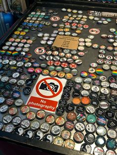 there are many different types of buttons on the table with no photography sign in front