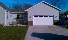 a white house with two garage doors on the front