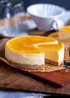 two cheesecakes sitting on top of a wooden cutting board