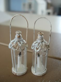 two clear glass candle holders sitting on top of a table