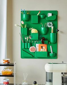 a green wall hanging with various items on it