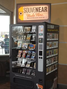 a vending machine sitting inside of a building next to a sign that says souvennear made here