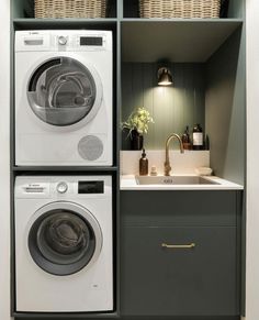 a washer and dryer in a small space with baskets on the shelves above