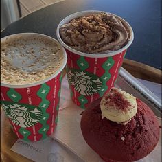 three different types of desserts on a tray with paper napkins and coffee cups