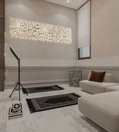 a living room filled with white furniture and arabic calligraphy on the wall above it