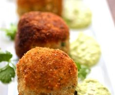 three crab cakes on a white plate with garnishes