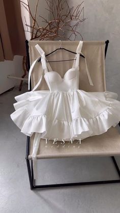 a white dress sitting on top of a chair