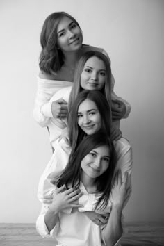 three women are posing for the camera with their arms around each other and one woman is holding