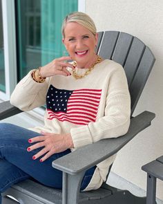 an older woman sitting in a chair with her hand on her chin and looking at the camera