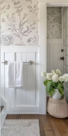 a white bathroom with floral wallpaper on the walls