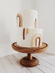 three tiered cake with white frosting and rainbow decorations