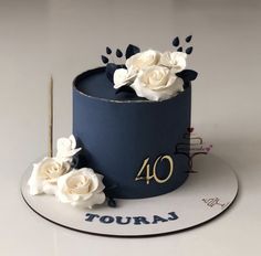 a blue cake with white flowers on top and the number forty four in gold lettering