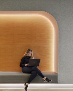 a woman sitting on a bench with a laptop