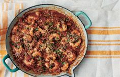 a pan filled with shrimp and sauce on top of a towel