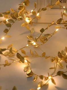 gold leaves and fairy lights on a white surface