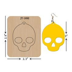 a pair of wooden earrings with a yellow skull on the front and back of it