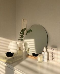 a white dresser topped with a mirror next to a lamp