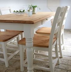 a kitchen table with four chairs and a potted plant on the counter top in front of it