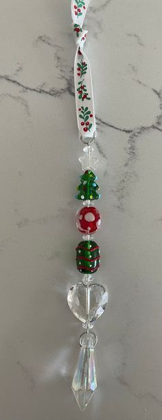 a glass ornament hanging from the side of a marble counter with beads on it