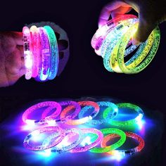 glow bracelets are being held by someone's hand and glowing in the dark