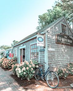 a bike is parked in front of a small building with flowers on the side and a sign that says old south wharf