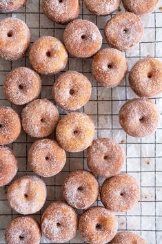 there are many sugared donuts on the cooling rack