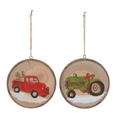 two christmas ornaments with an old red truck and tractor in the snow, hanging from twine strings