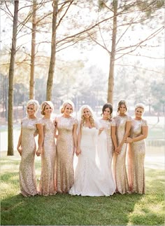 a group of women standing next to each other on top of a grass covered field