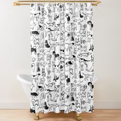 a shower curtain with black and white dogs on it, in front of a bathtub