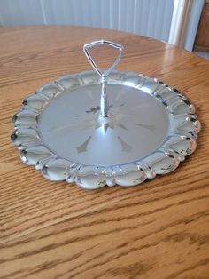 a silver plate sitting on top of a wooden table