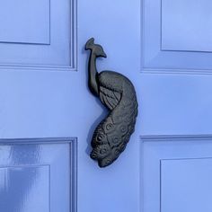 a metal door knocker with a bird on it's side hanging from a blue door