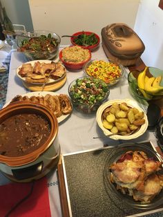 a table full of food including meat, potatoes and salads