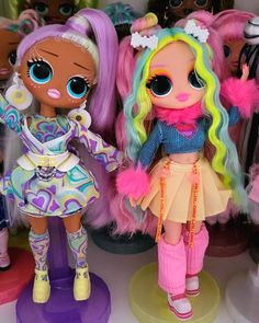 two dolls are standing next to each other in front of many other doll's