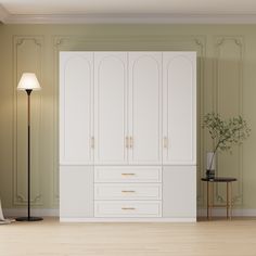 an empty room with white cabinets and a lamp on the floor next to a chair