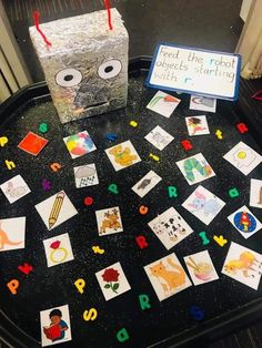 a black table topped with lots of cards and a box filled with magnets on top of it