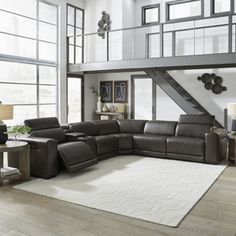 a living room with large windows and a sectional couch in the middle of the room