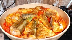 a bowl filled with fish and vegetables on top of a stove