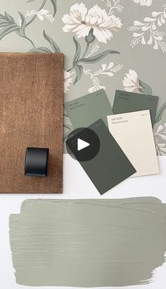 some paint swatches are sitting on a table next to a wooden board and brush