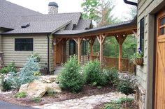 a house that has some plants in front of it and rocks on the ground outside