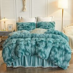 a bed covered in blue fur with white pillows