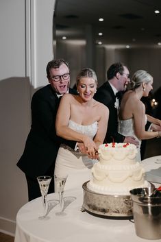 a bride and groom cutting their wedding cake