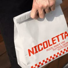 a close up of a person holding a bag with the word nicetta on it