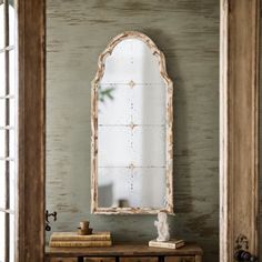 an old dresser with a mirror on it in front of a door and window sill