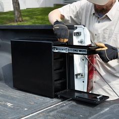 a man in white shirt and black gloves working on an appliance