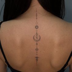 the back of a woman's neck with an intricate tattoo design on her lower back