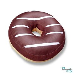 a donut with chocolate frosting and white stripes sitting on top of a pillow